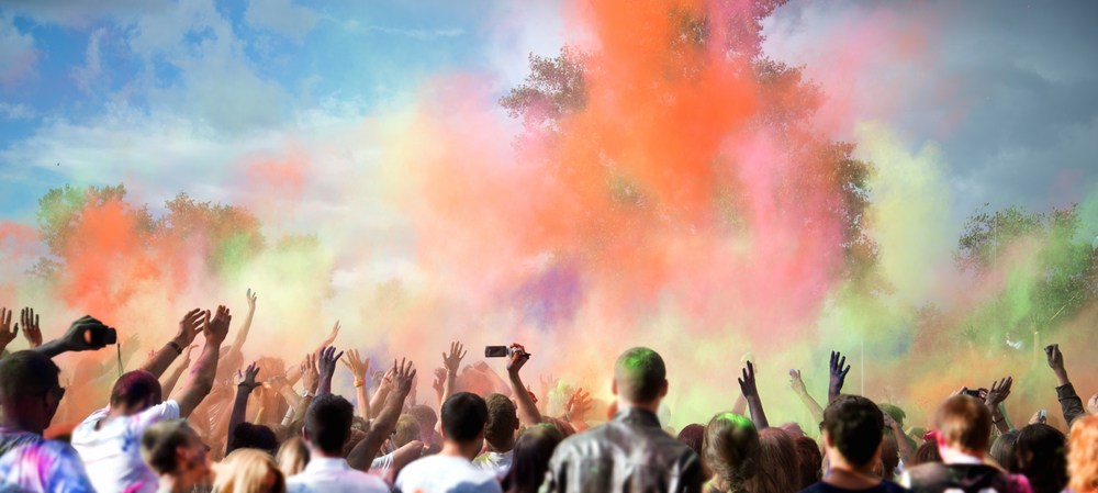 Crowd celebrating holi festival with colours in the air