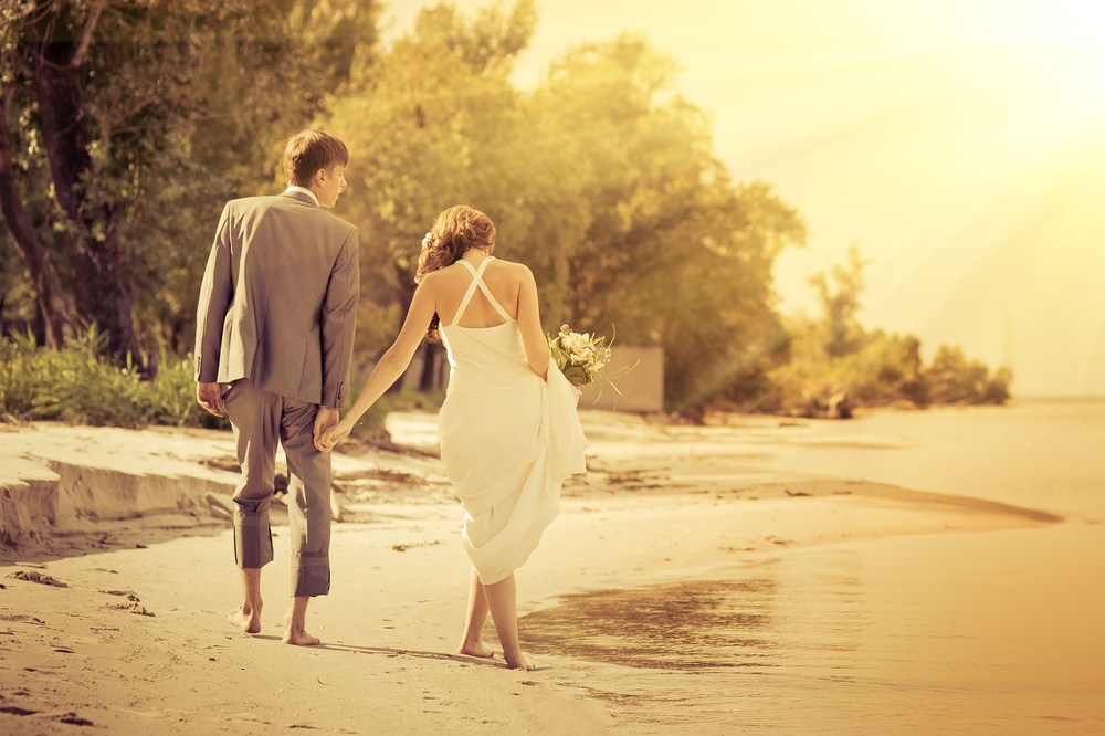 Just married couple walking along beach