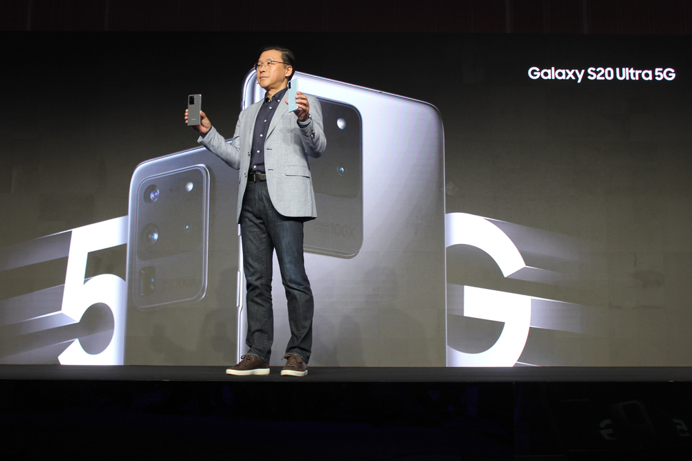 speaker on stage with screen behind him.