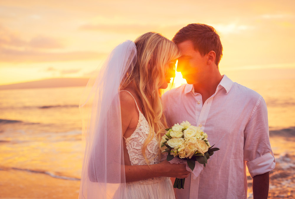 Couple kissing on beach in golden hour