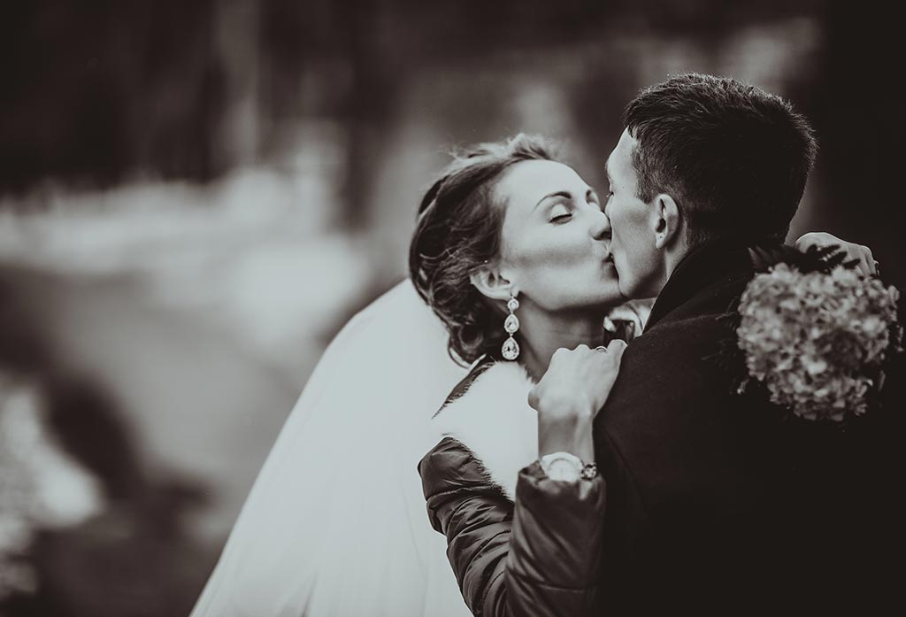 Black and white photo of married couple kissing